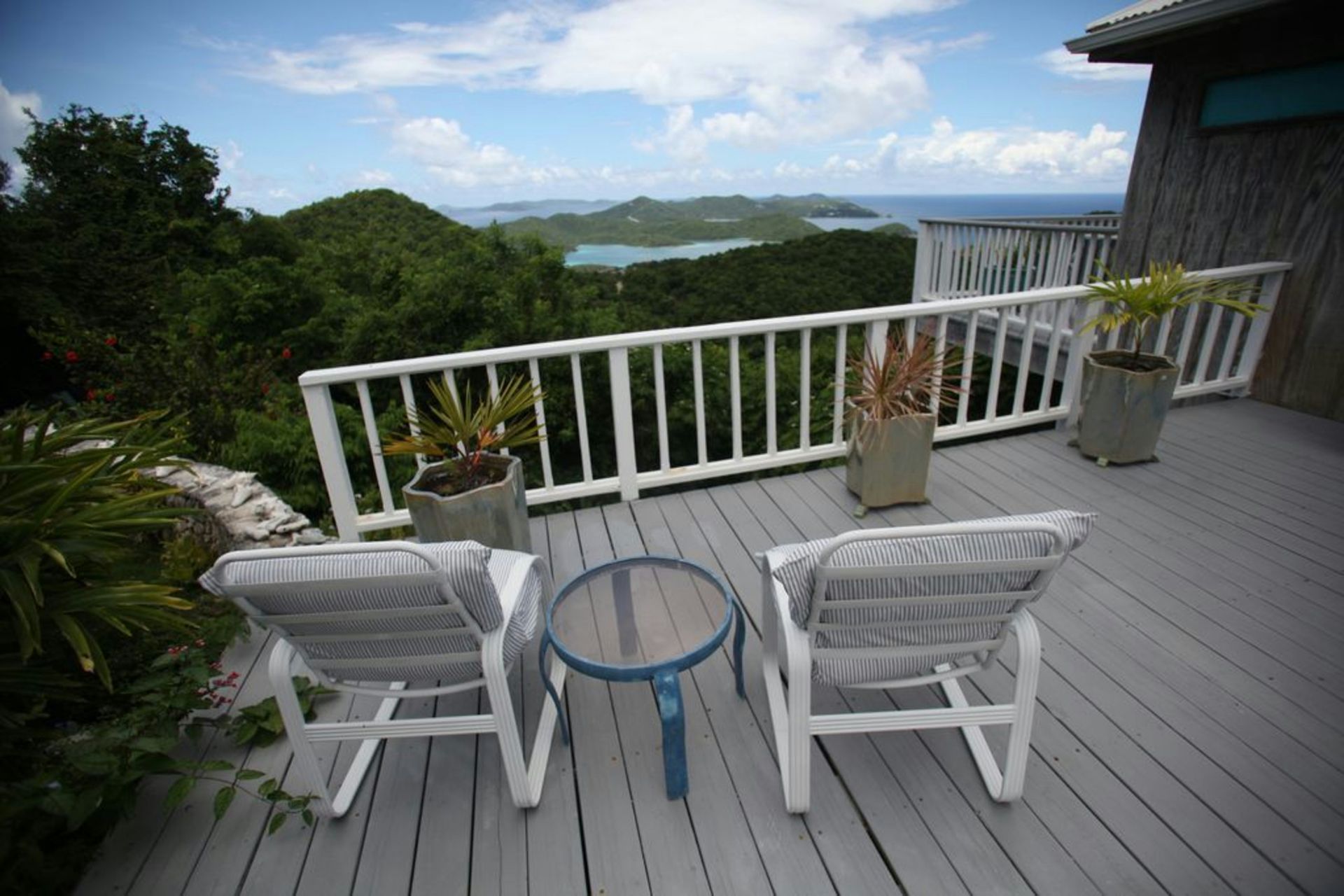 Deck with lounge chairs overlooking a tropical ocean view